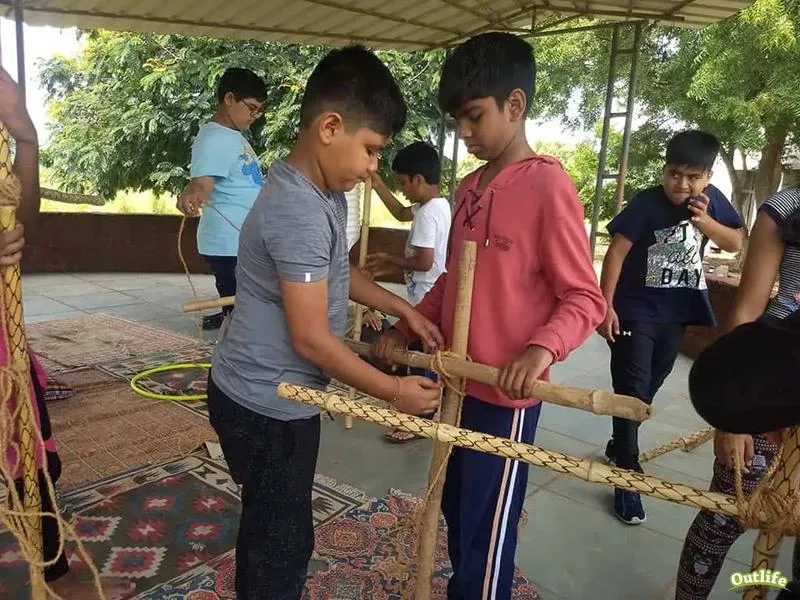 Kids constructiing shelters using knots and lashings at the outdoor school camp